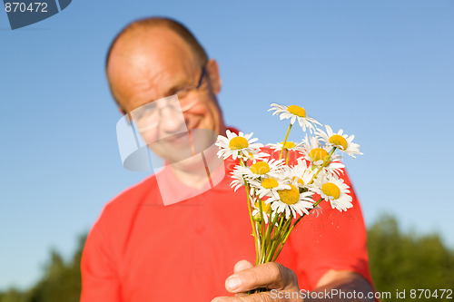 Image of Middle-aged man giving flowers