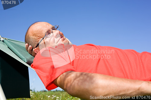 Image of Happy man lying on hammock