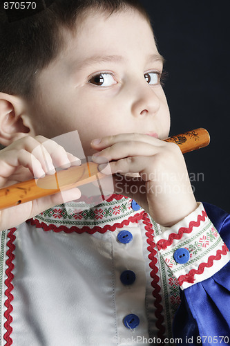 Image of Little boy playing wooden flute