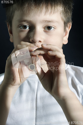 Image of Boy in white playing wooden pipe
