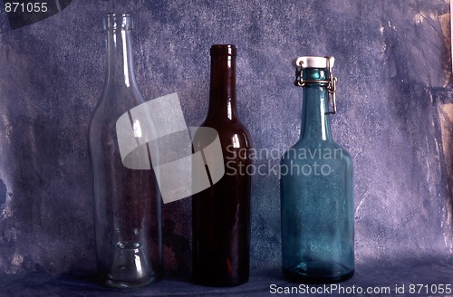 Image of Three old empty bottles on painted background