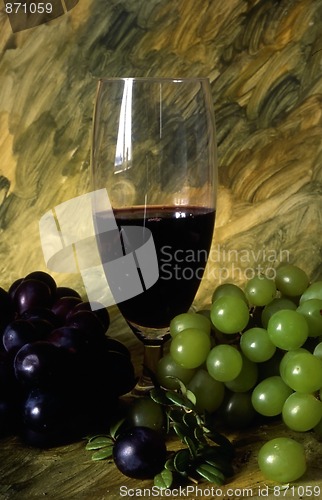 Image of A glass of wine with grapes on painted background