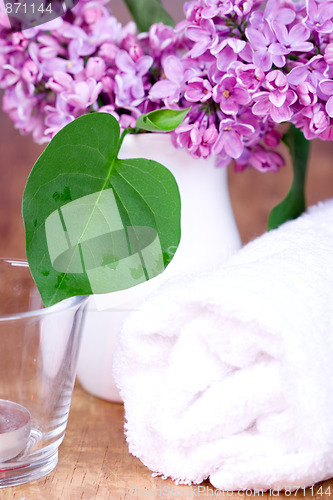 Image of rolled towel, lilac and candle