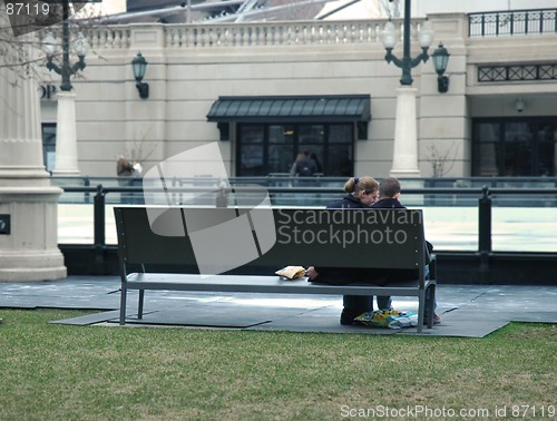 Image of Young couple sitting on a park bench