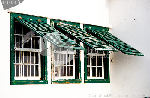 Image of Three old green windows from a typical beach house.

