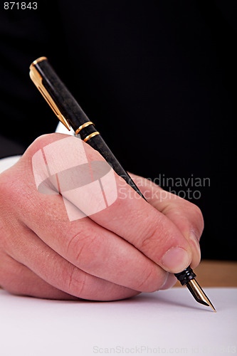 Image of businessman signing a document  with a fountain pen 