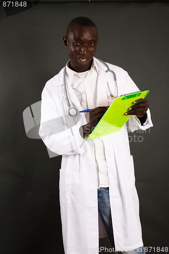 Image of Doctor writing on a clipboard standing isolated over a black background

