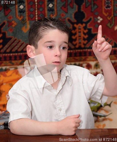Image of Serious cute little boy raises his finger