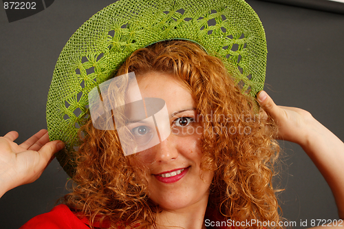 Image of Girl trying on a green hat