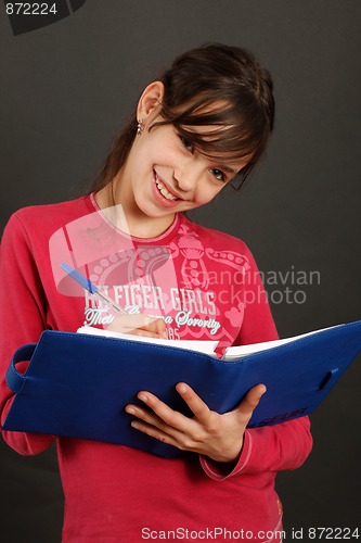 Image of Young girl writing on a binder