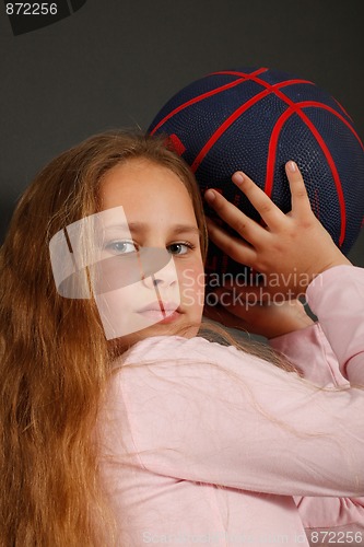 Image of Young girl play with a basketball ball