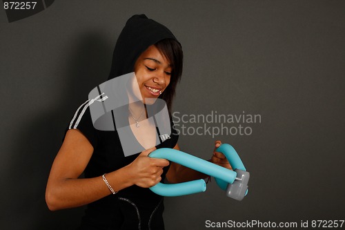 Image of  Young woman doing fitness exercises with thigh master