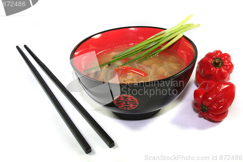 Image of Thai soup with chopsticks and red pepper