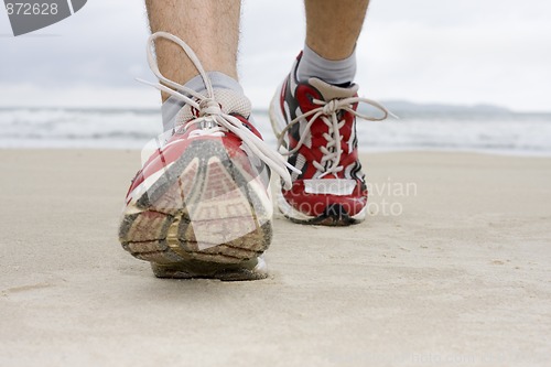 Image of Feet of man jogging on a beach