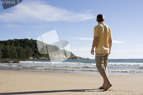 Image of Man walking barefoot on a tropical beach