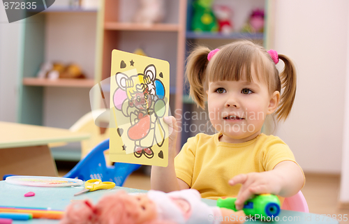 Image of Little girl showing a picture in preschool