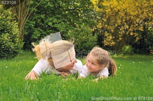 Image of Young mother and daughter laying on the grass