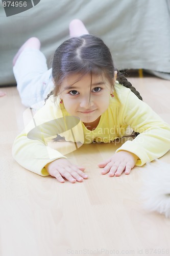 Image of Little girl in yellow laying on floor