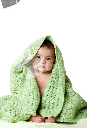 Image of Cute baby sitting between green blanket.