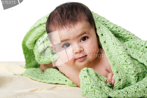 Image of Cute happy baby between green blankets