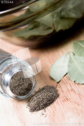 Image of black pepper in shaker and bay leaves