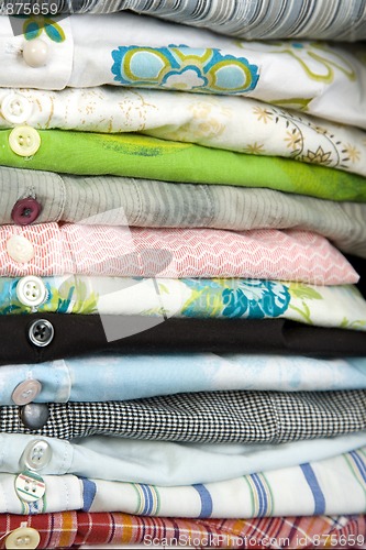 Image of stack of colored shirt, details of buttons