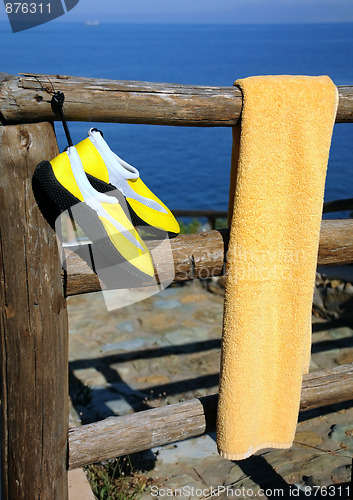 Image of Towel and Beach Shoes on Wooden Fence
