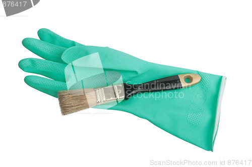 Image of One green rubber glove and brush.