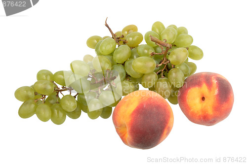 Image of Green grapes bunch and two orange peach.