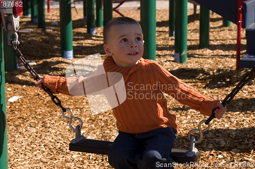 Image of Child looking up while sitting on the swing