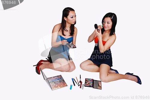 Image of Two Chinese girls doing makeup.