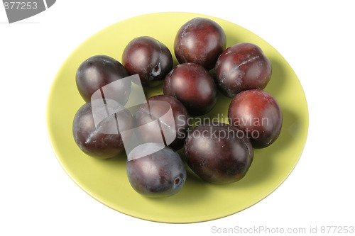 Image of Group of dark-purple plums on plate.