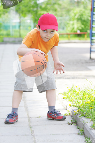 Image of Little boy dribbling basketball