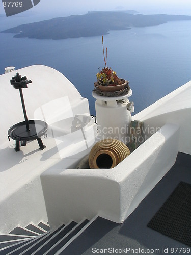 Image of Steps, vase, and whitewashed walls, with volcano island in background, Santorini, Greece