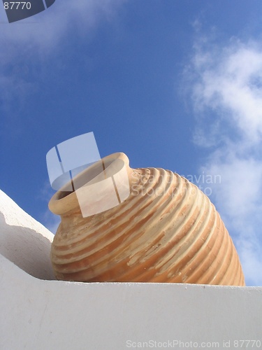 Image of White wall, beige vase, blue sky, Santorini, Greece