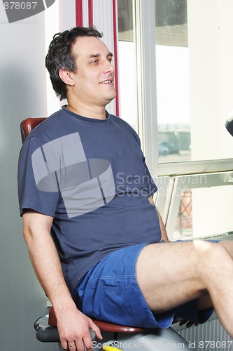 Image of Smiling man working out on bicycle machine