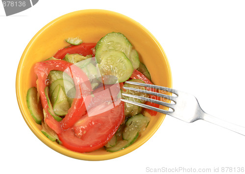 Image of Salad from fresh cucumbers and tomatoes on a yellow plate