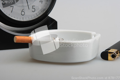 Image of Clock and white ashtray with cigarette