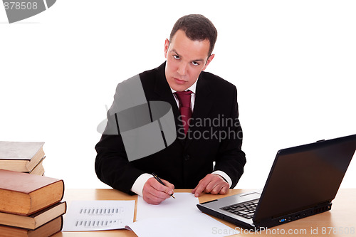 Image of businessman on desk with books and computer, working
