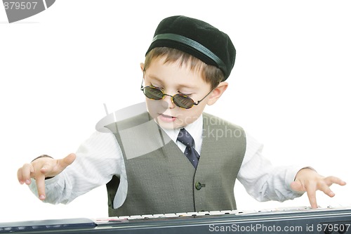 Image of Cute kid in sunglasses playing piano