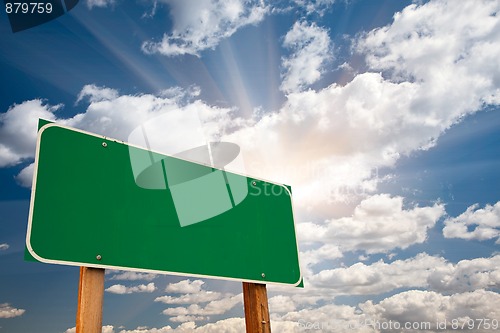 Image of Blank Green Road Sign Over Clouds and Sunburst