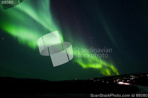 Image of Aurora Borealis arc over hill terrain