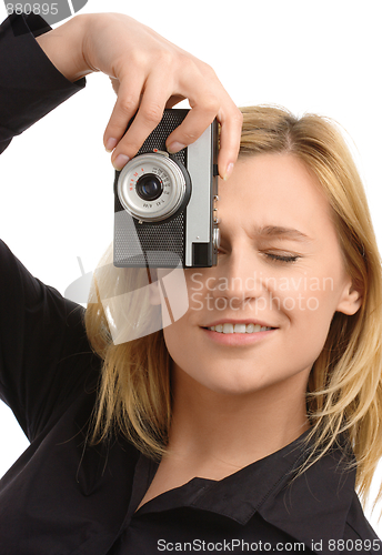 Image of young woman taking a shot with photo camera