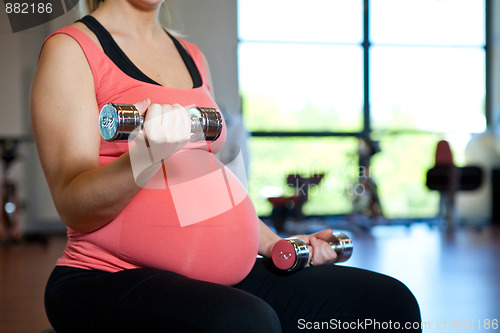 Image of Pregnant woman exercising with weights