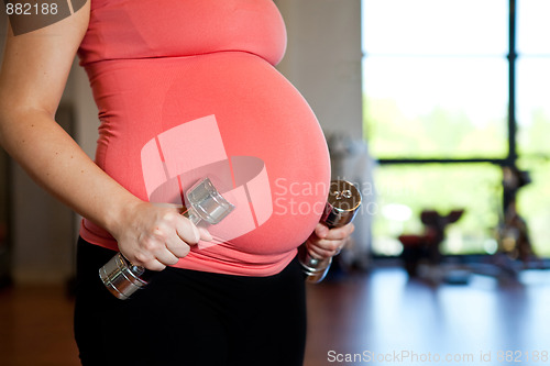 Image of Pregnant woman holding dumbbells