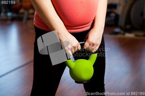 Image of Pregnant woman exercising with a kettlebell