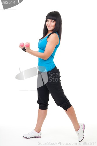 Image of Young positive woman holing dumbbells