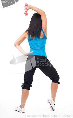 Image of Back of woman standing and exercising with dumbbell