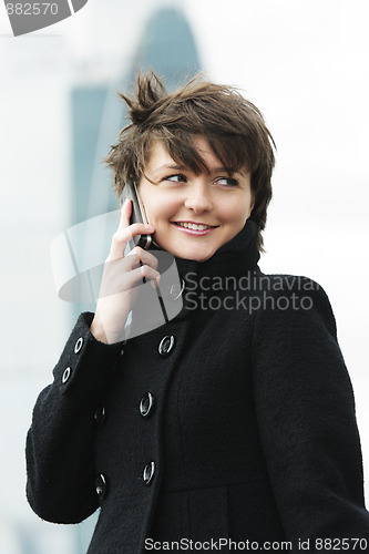 Image of Woman on cellphone in windy day