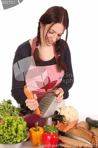 Image of housewife preparing lunch and cutting carrot 